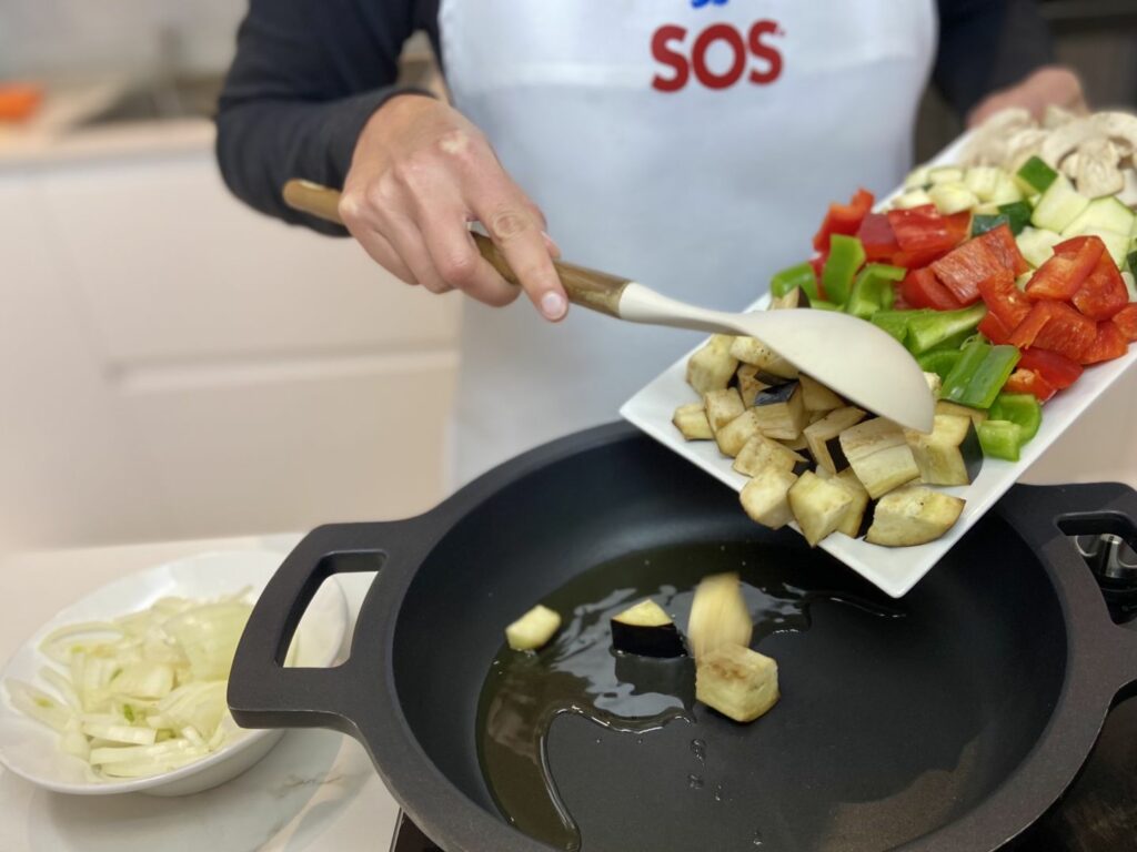 Picamos el ajo, la cebolla, los pimientos y todas las demás verduras y las añadimos a la sarten una a una