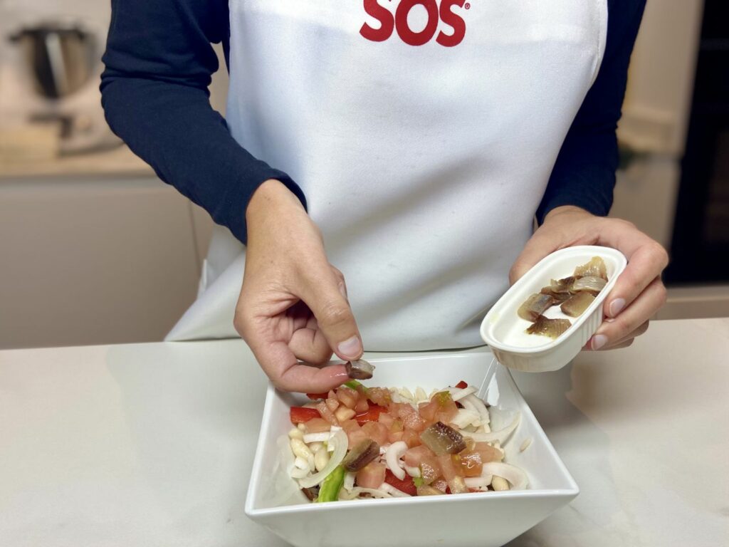 picamos las anchoas bien escurridas y también el tomate, en cubos menudos. y lo integramos todo bien