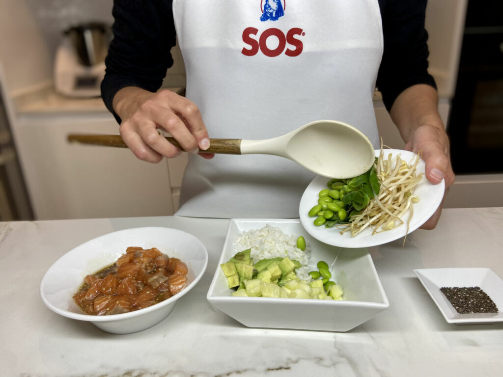 Repartimos por el bowl el aguacate, los trozos de pepino, los brotes de soja, los edamames y los brotes tiernos.