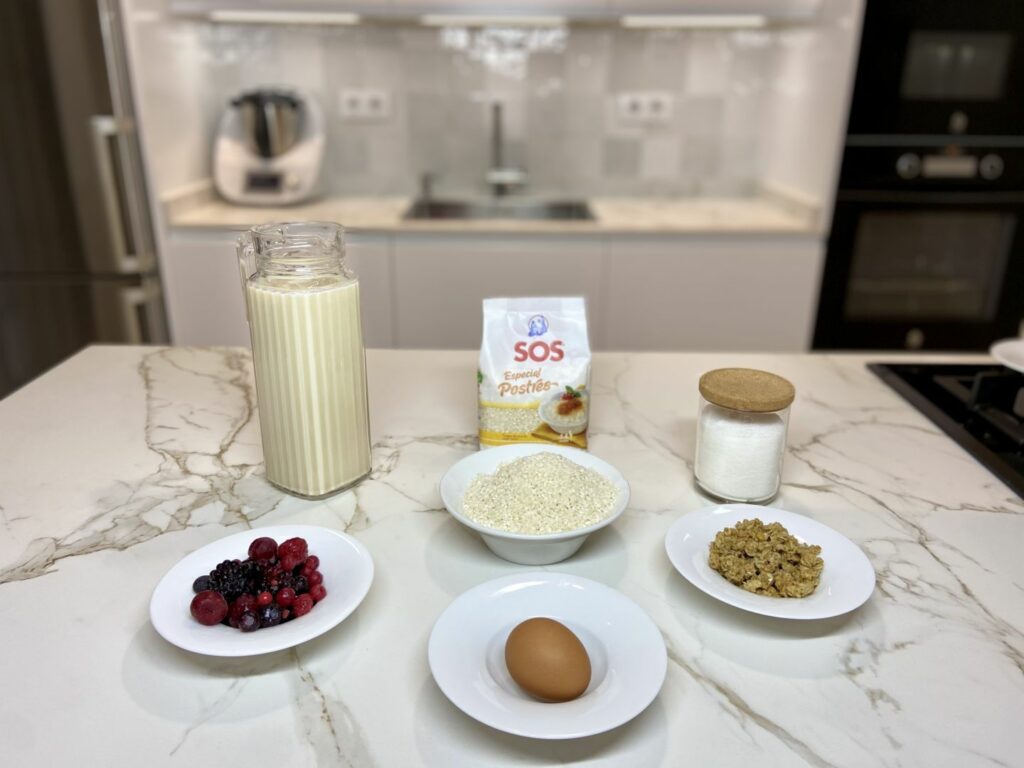 Debemos tener a nuestra disposición todos los ingredientes necesarios: el arroz, la leche de avena, el azúcar, los frutos rojos, la yema de huevo, etc.