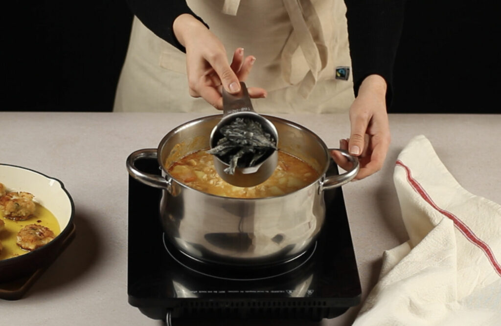 Receta arroz con garbanzos paso 5 añadimos el bacalao, los copos de wakame y las bolas fritas