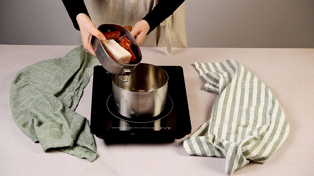 Receta arroz con judías pintas paso 2 ponemos a cocer el tocino y el chorizo con agua