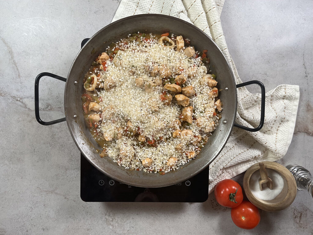 Paella con pollo y marisco paso 4 agregar el arroz