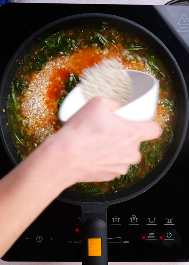 Verter caldo, sal e incorporar arroz a arroz con espinaca y garbanzos