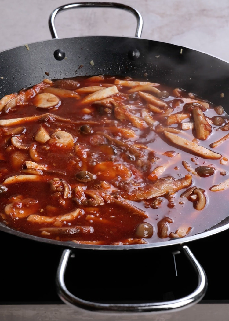Añadir tomate, pimentón y vino para fideuá de setas