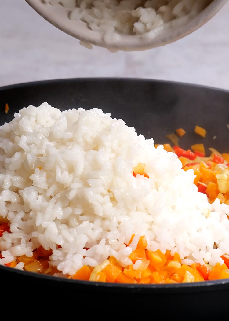 Añadir arroz a sartén en arroz con verduras fácil para niños