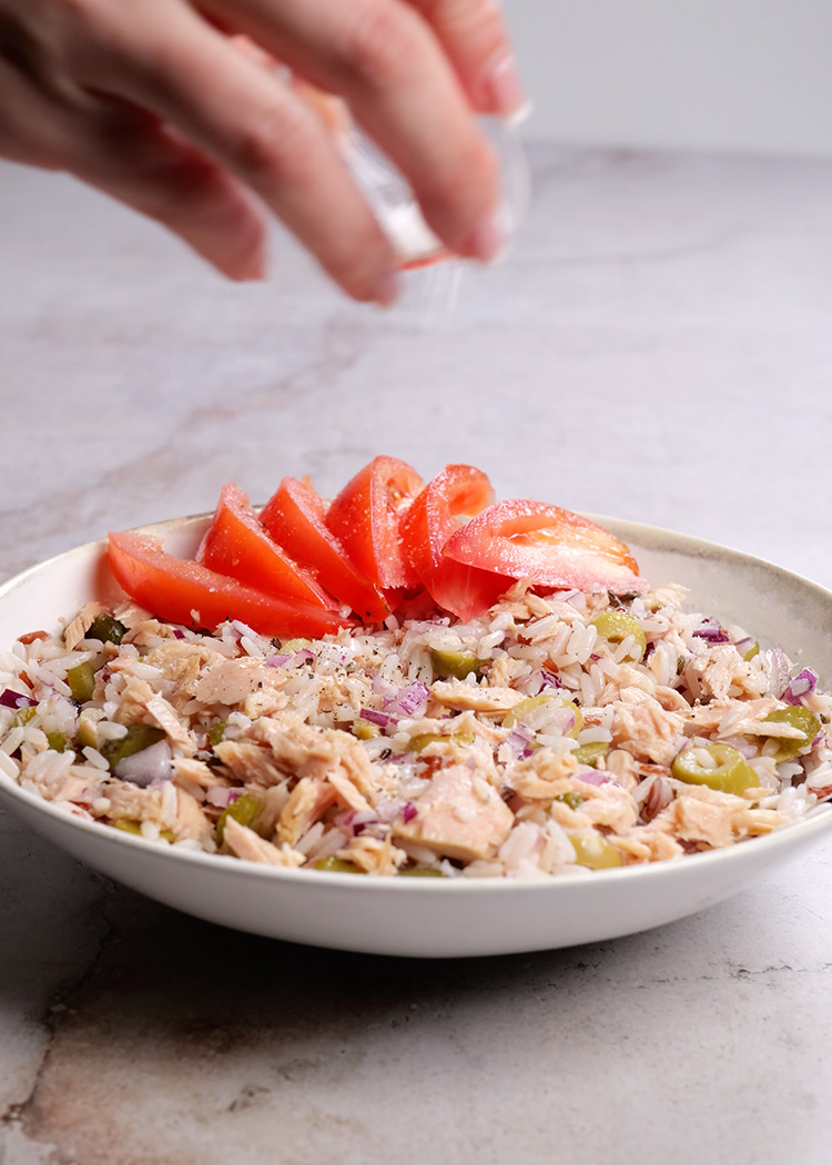Tomates, sal y pimienta en ensalada de arroz con tomate y atún