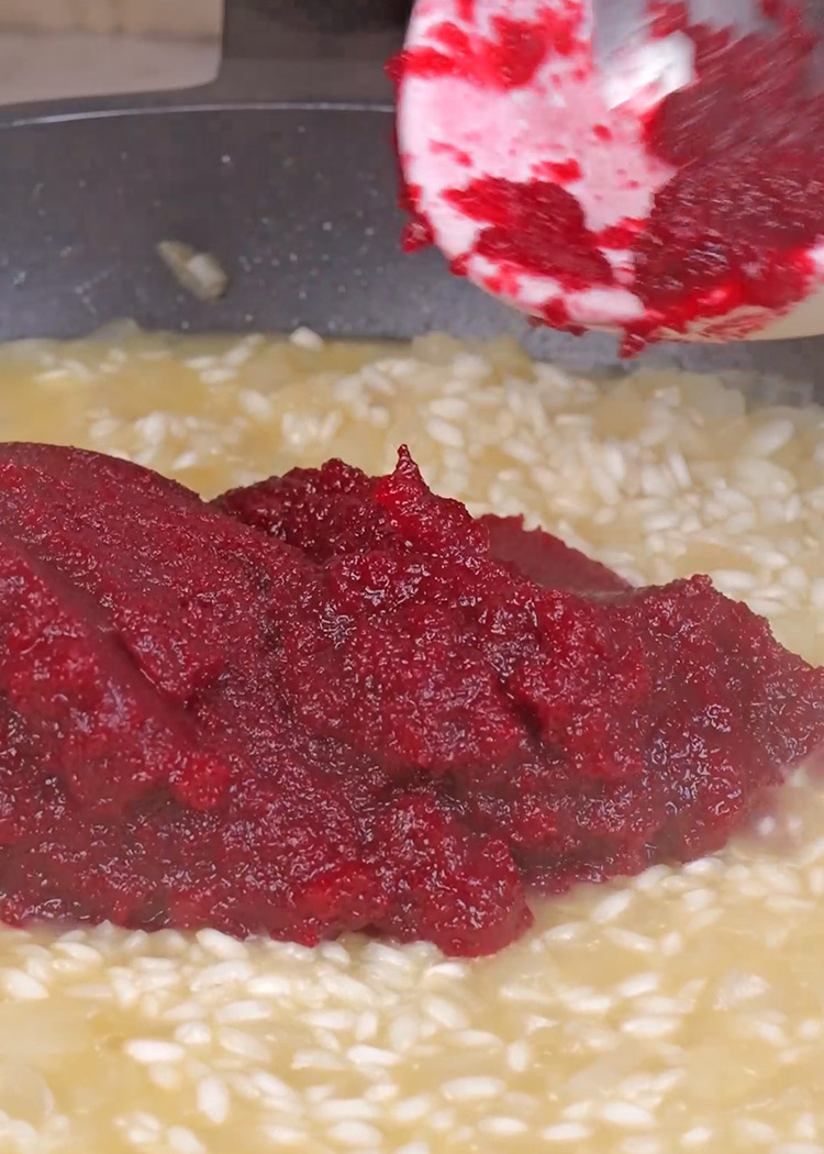 Añadir un cazo de caldo y puré de remolacha a risotto de remolacha