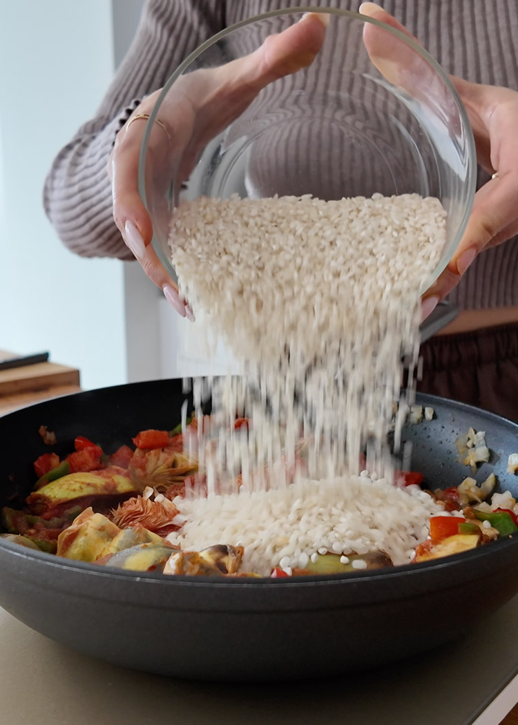 Verter arroz a arroz con alcachofas y verduras