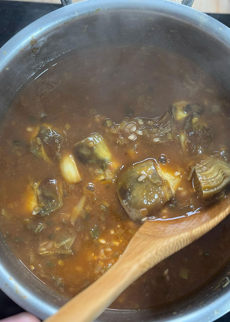 Verter caldo a Arroz meloso con langostinos y alcachofas