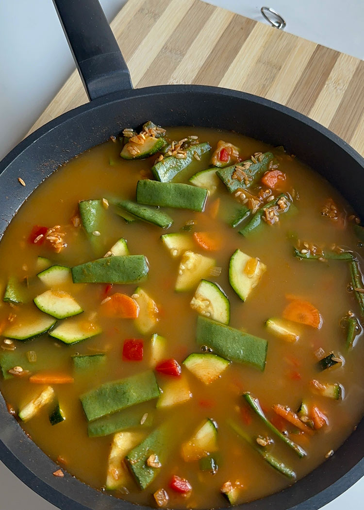 Añadir arroz y caldo a arroz integral con verduras