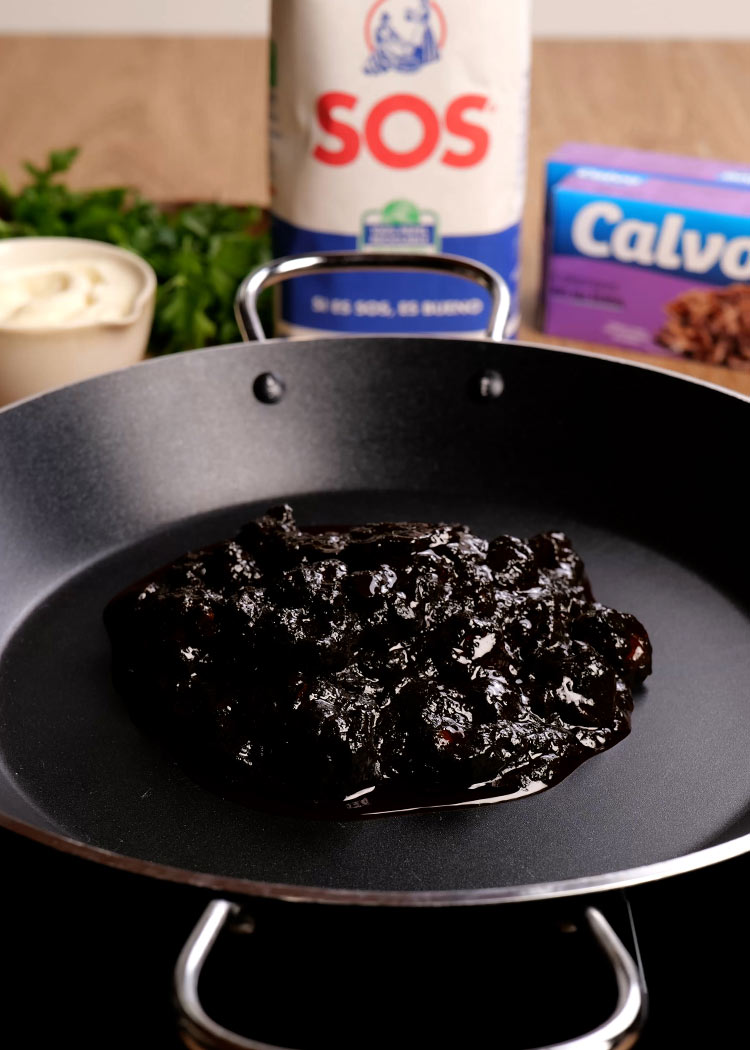 Añadir calamares en su tinta a sartén en Arroz con calamares en su tinta