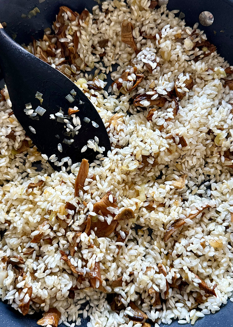 incorporar arroz y vino para risotto de boletus
